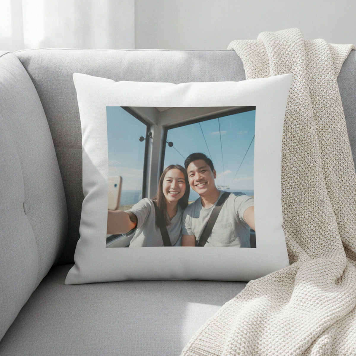 White 30 cm square photo cushion with a 20 cm photo print of a couple, on a grey sofa