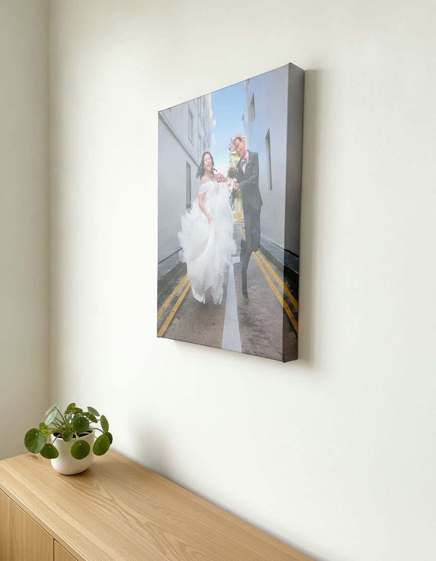 Mirror-wrapped photo canvas of a wedding couple hanging above an oak sideboard