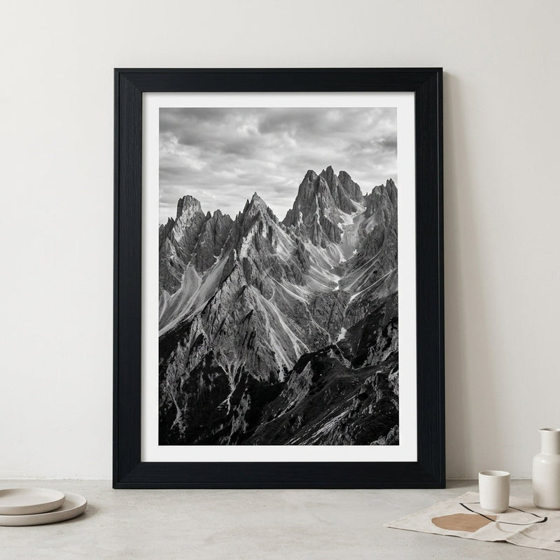 Large framed poster in a wide black wood frame leaning against a wall