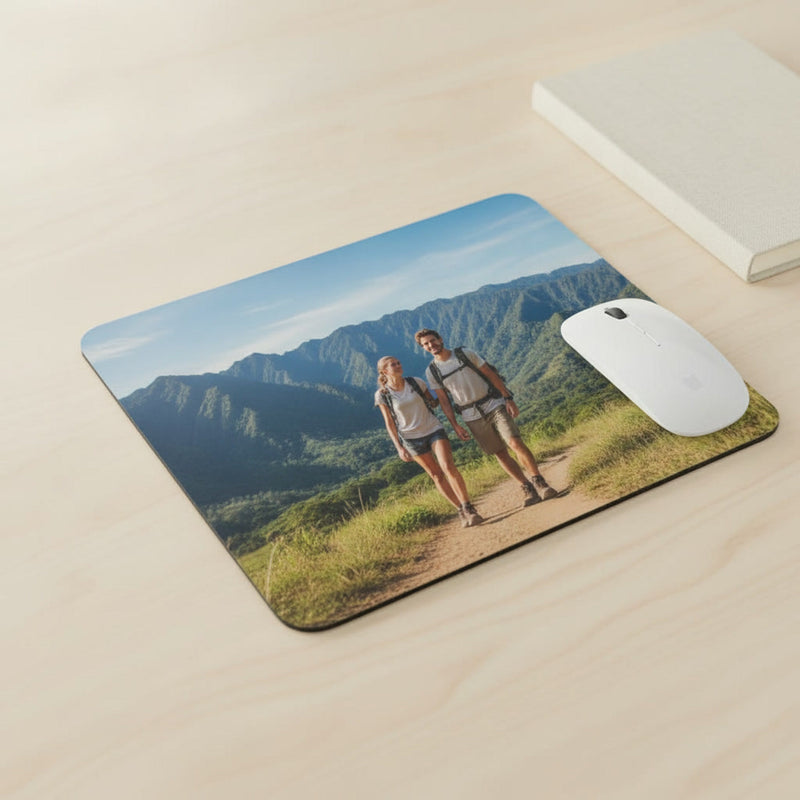 Overhead view of a rectangular photo mousepad with rounded corners next to a mouse